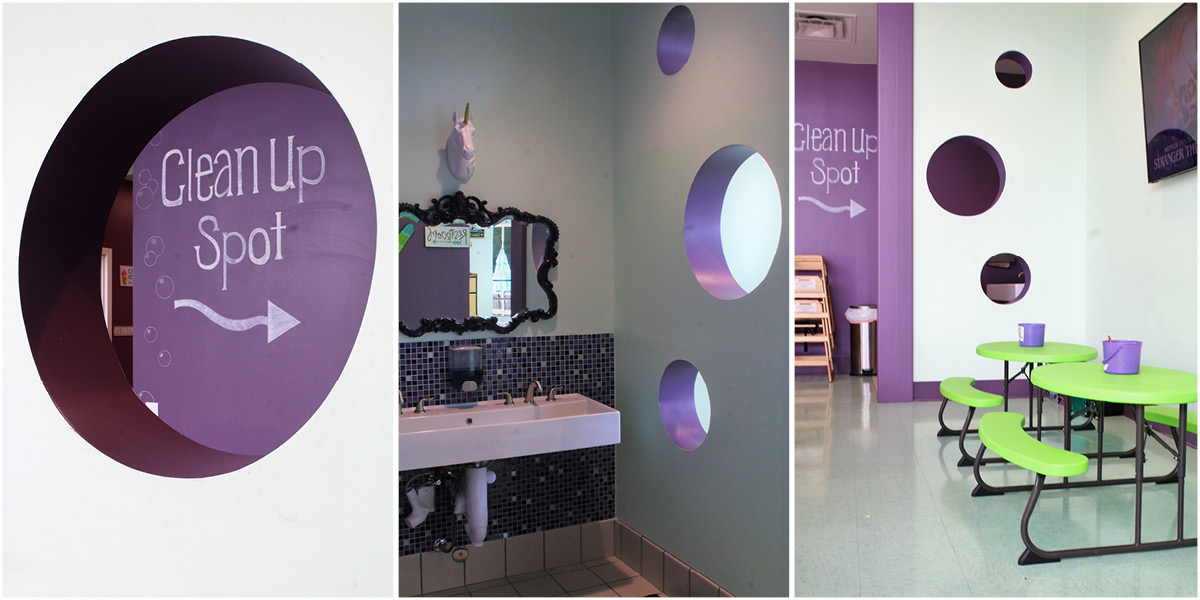 Playful cleanup area at Bee’s Neez Cones & Coffee in San Antonio with purple accent walls, decorative mirror, and family-friendly seating.