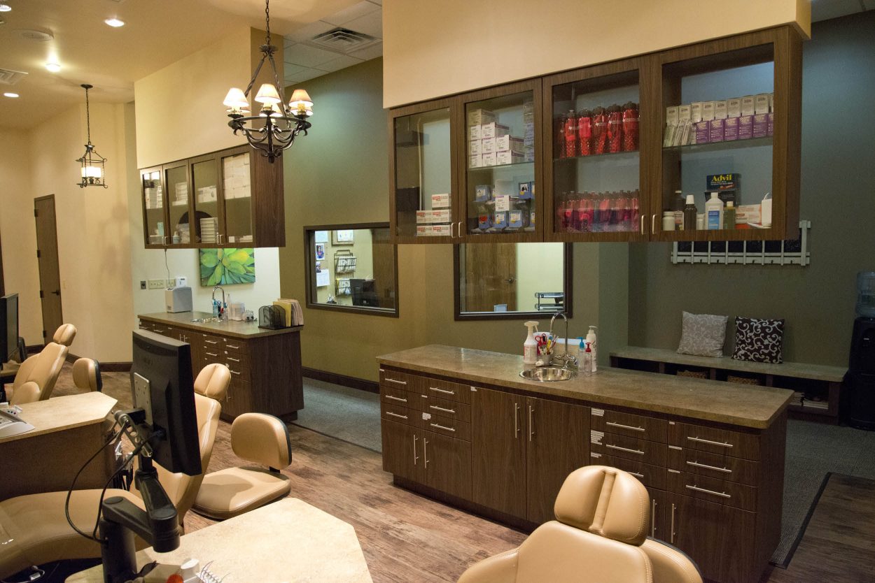 STO-2 Open treatment area featuring multiple orthodontic chairs, overhead cabinets, and task lighting in San Antonio clinic.