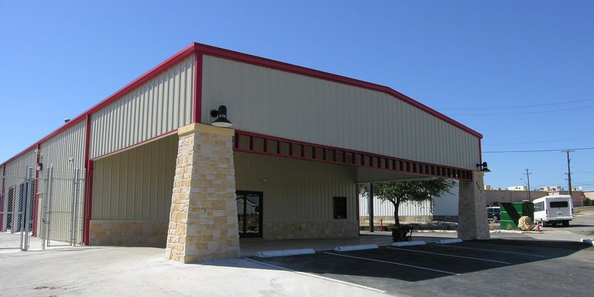 autobody -2 Exterior view of renovated autobody shop metal building with stone base, red trim, and covered entry