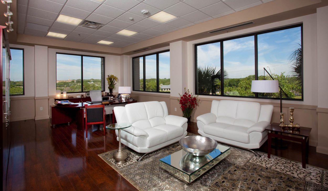 TRI-LIN Office Finish-Out – Executive office with large windows, contemporary furniture, and natural lighting in San Antonio office renovation