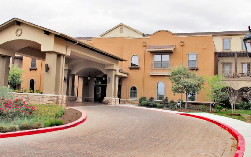 Completed porte-cochere addition with landscaped entrance at Villa de San Antonio senior living community.