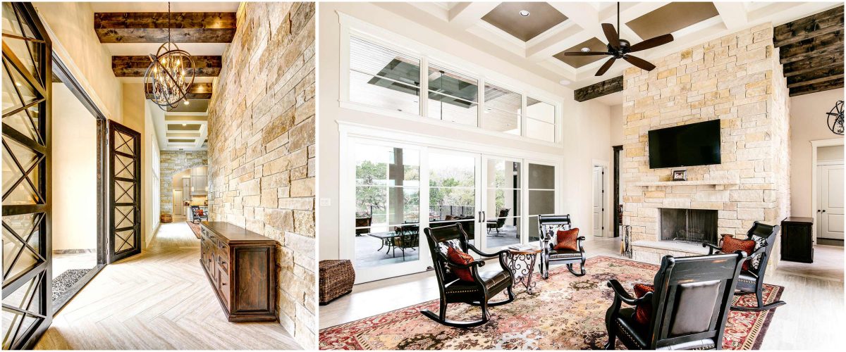 4880-3 legant stone-accented hallway with exposed wood beams leading into a spacious living room featuring a stone fireplace, coffered ceilings, and large windows overlooking the patio.