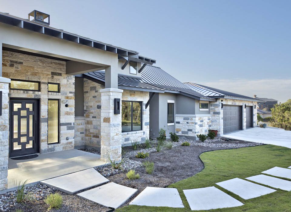 Front elevation showcasing stone and stucco finishes at Hill Country home Plan 4690
