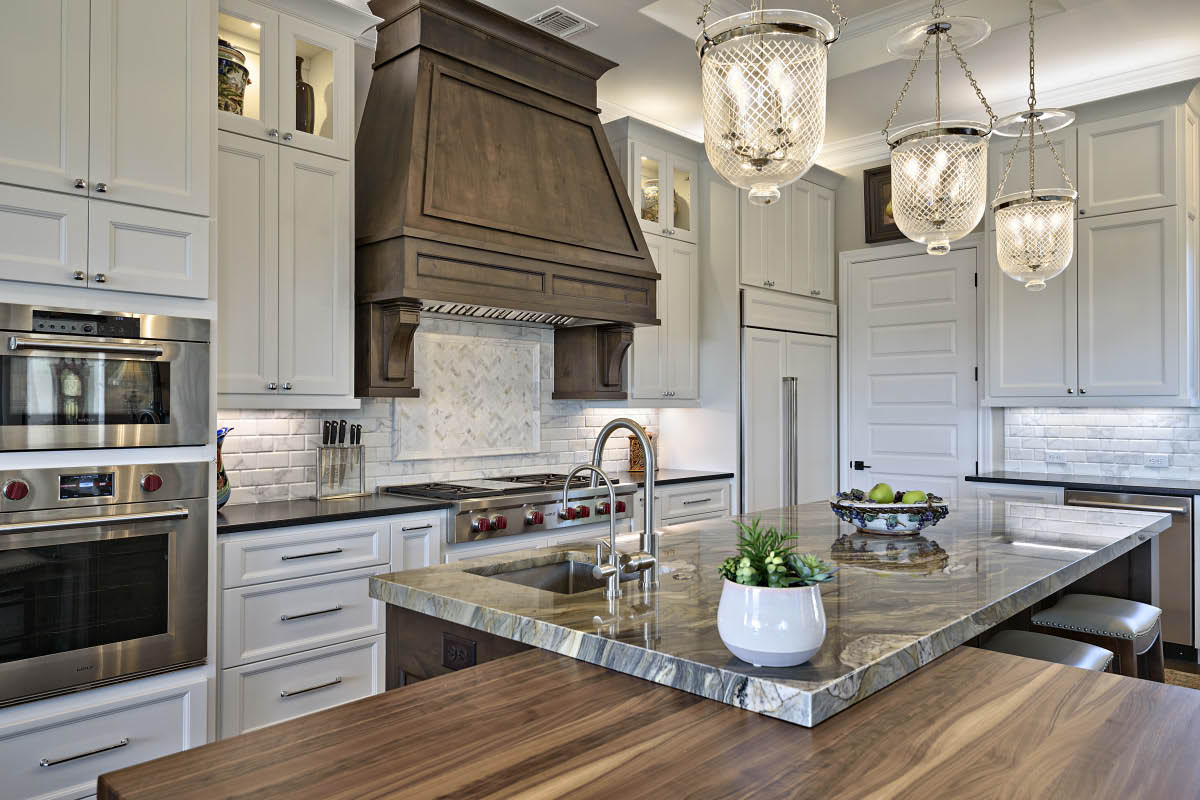 4690-4 Luxury kitchen with marble island, custom wood hood, and pendant lighting designed by MSA Architecture + Interiors