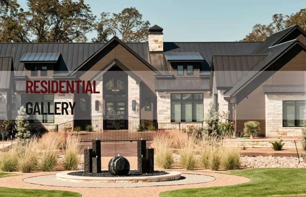 Modern luxury home in San Antonio designed by MSA Architecture + Interiors featuring stone exterior, black metal roof, and landscaped front courtyard fountain on Legends Parkway
